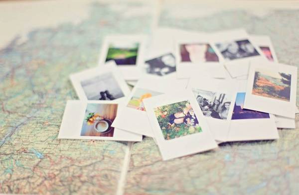 Mehrere Polaroid-Fotos liegen verstreut auf einer Landkarte